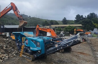 Powerscreen pt400x working on demolition site in Auckland being loaded with waste demolition concrete for crushing into reusable aggregate