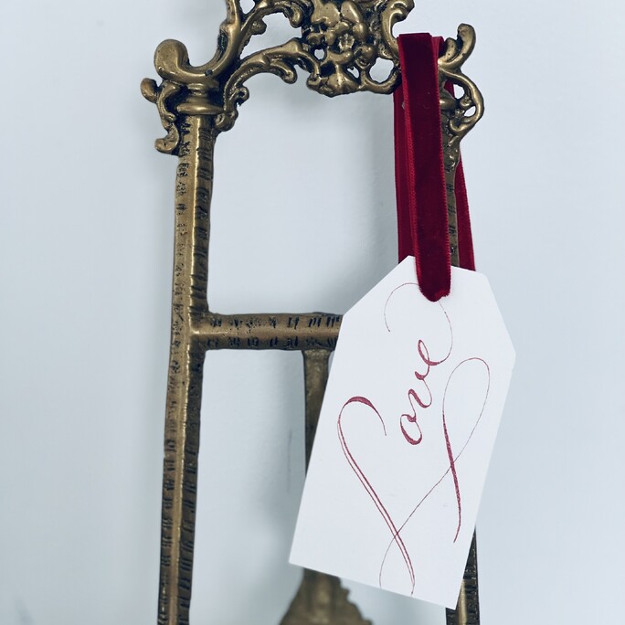 Our ruby love gift tag handing on an ornate standing picture frame.