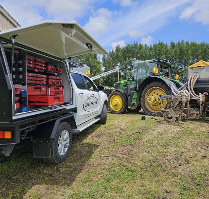 Truck and tractor parked in a paddock