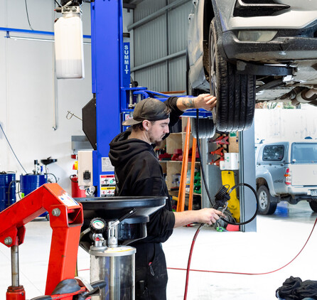 Man servicing a car checking tire pressure