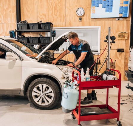 A man working on the air conditioning of a car