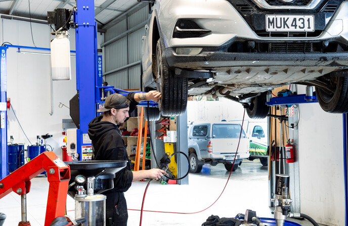 Man working on the tire pressure of a car