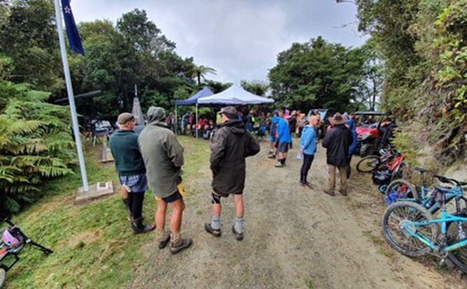 Travellers gather for the 2021 ANZAC commemoration with an array of mountain bikes, quads and tramping boots. The two canopies were vital: during proceedings, the only squall of the day passed through. On the left are the flag pole, ANZAC monument, story shelter, and barbeque