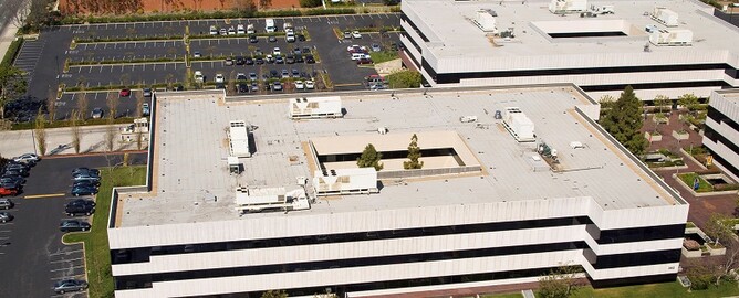 Flat roof buildings compatible with silicone roof membranes