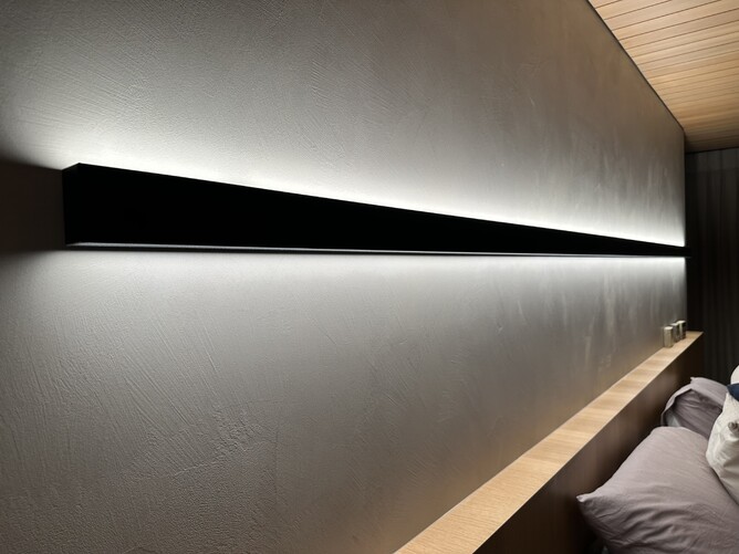 Bedroom with black square light strip above bed