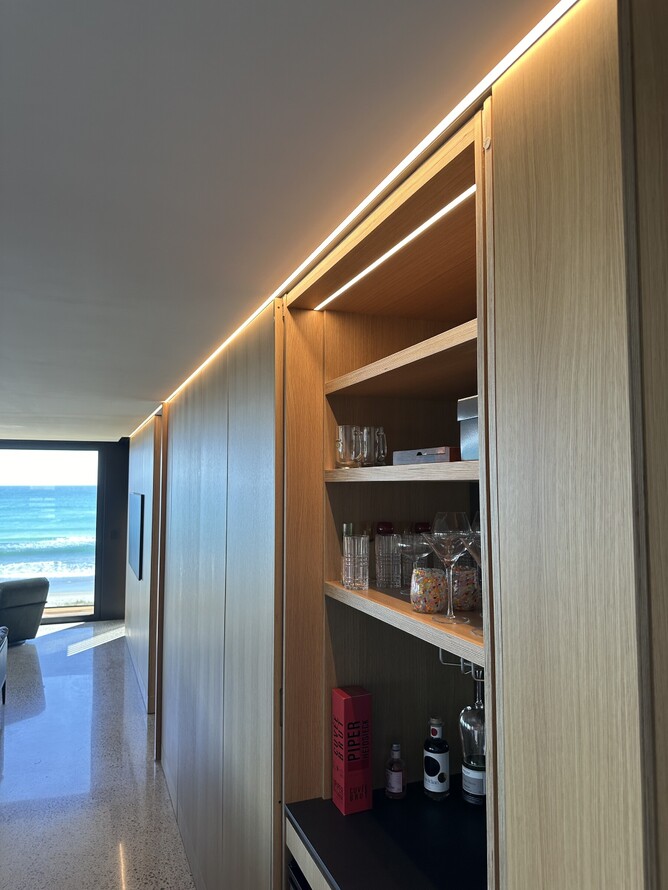 Lounge with bar and linear light strip extending to ocean-facing windows