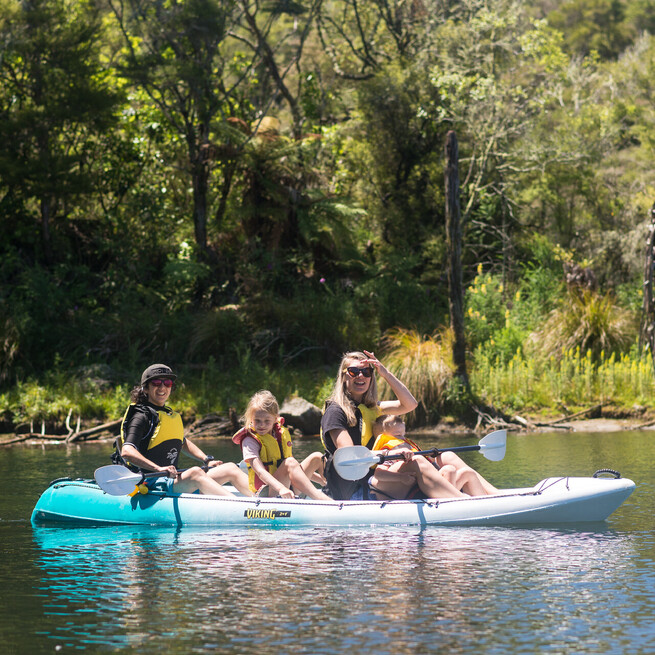 Women and Children kayak on Lake Rotomahana immersed in Waimangu Nature