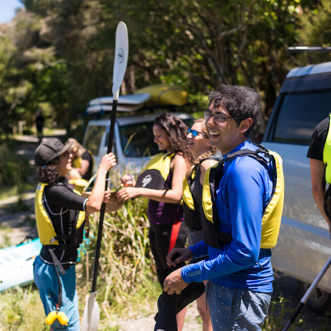 A customer smiles for the camera on the Steaming Cliffs Kayak Tour