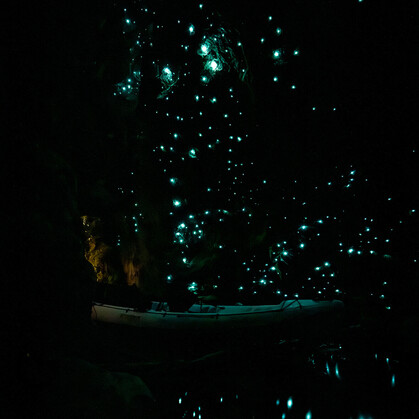 a kayak in a glow worm cave with the glow worms all lit up