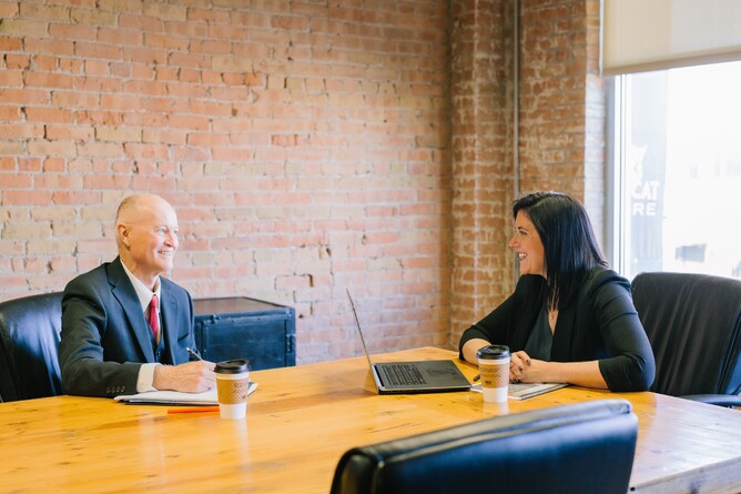 Two professionals having a meeting over coffee