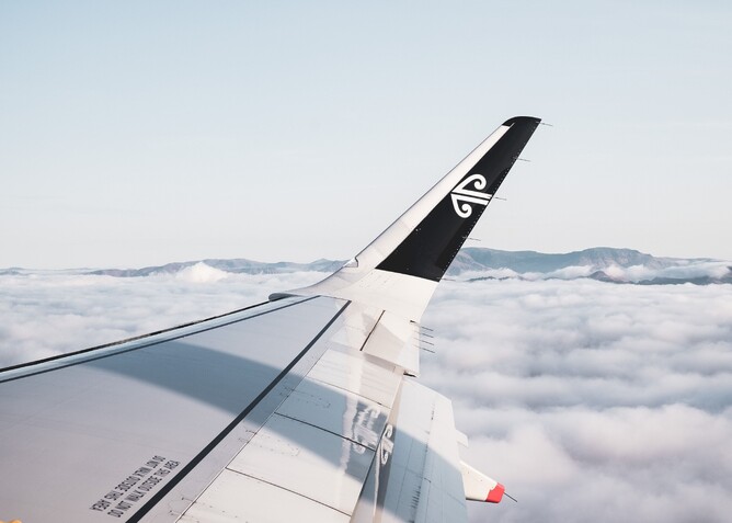 Air New Zealand plane wing flying above the clouds