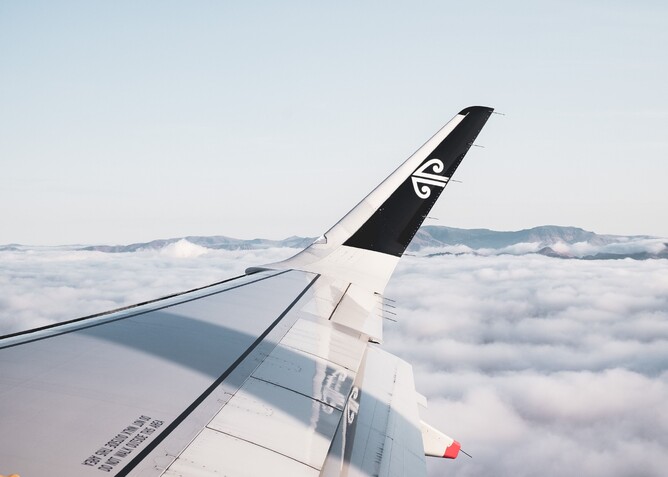 Air New Zealand plane wing flying above the clouds
