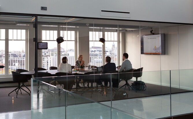 Group of people in a modern boardroom, discussing governance and leadership role