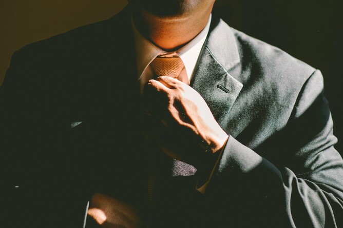 Person adjusting their tie, symbolising board maturity and leadership, relevant to GGA's governance insight