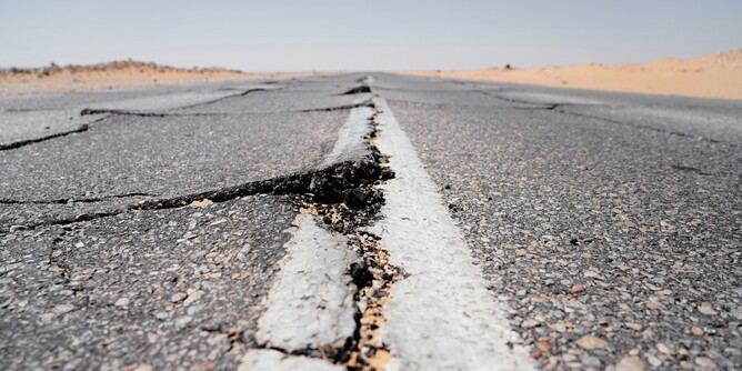 Cracked and damaged road in a desert landscape