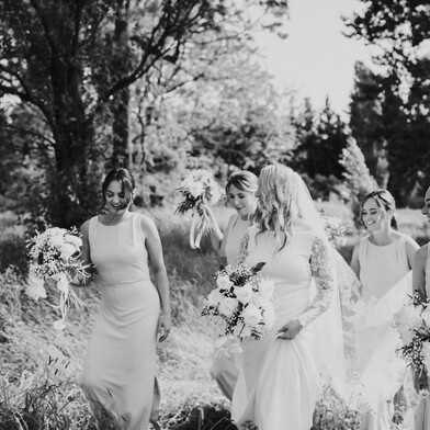 Wedding Planning and Styling by The Event Girl - bride and her bridesmaids walking through a field