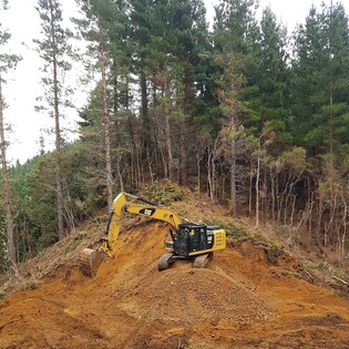 Stage 1 - forestry road service - excavator digging a shingle pit
