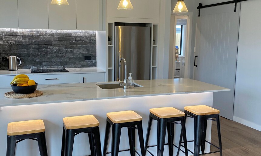 Under-bench and upper-cabinetry lighting in this kitchen creates a unique feel in the heart of this home.