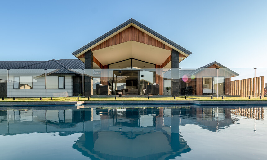 Stylish pool surrounded by glass pool fencing shows the high-quality craftsmanship of the builders at Linecrest Homes.