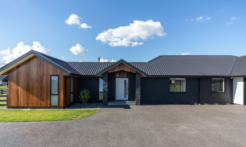 This stunning mixture of natural wooden panels and black exterior make it an award-winning house built in Cambridge, Waikato.