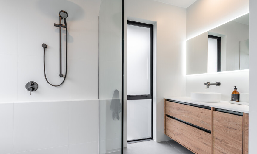 This elegant bathroom, built by Cambridge builders, Linecrest Homes, has a backlit mirror and walk-in shower.