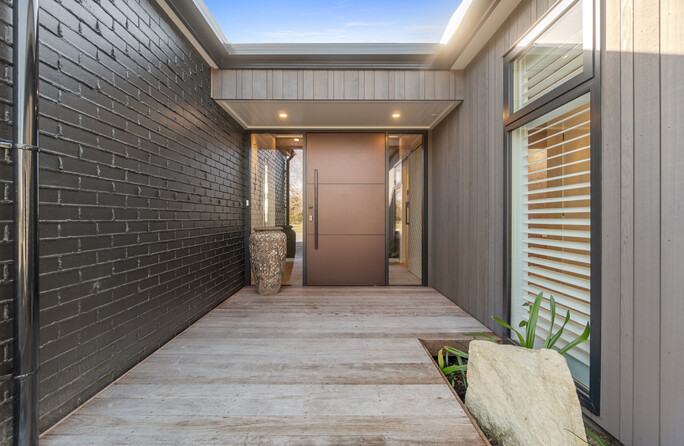 Custom-built front door and a bespoke designed entrance features dark and natural tones, make this home truly distinctive.
