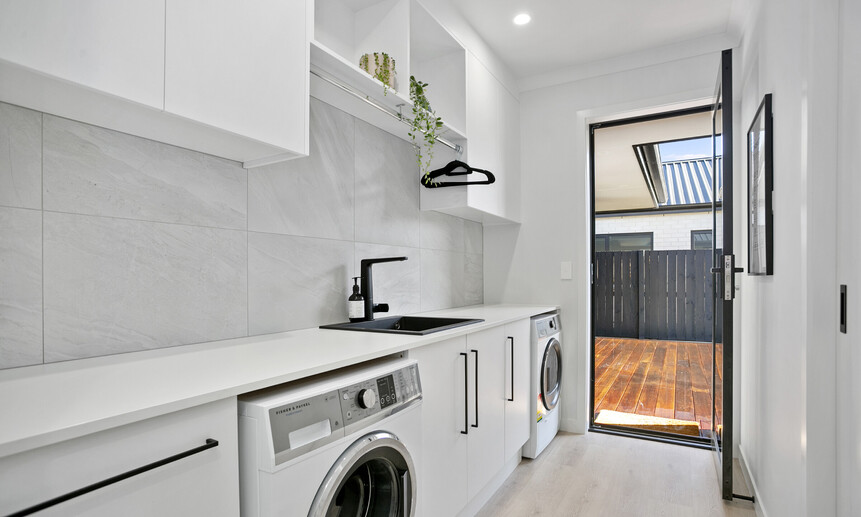 Sleek galley-style laundry featuring custom joinery and minimalist finishes add to a winning build by Linecrest Homes.