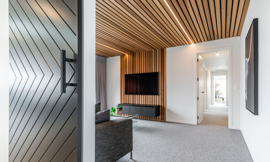 Cleverly designed lines adorn this entertainment room with wooden ceiling panel & strip lighting built by Linecrest Homes.