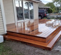 Polished hardwood deck with double steps leading to sliding doors – built by expert deck builders in Christchurch for a seamless indoor-outdoor 