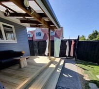Covered backyard deck with wide timber steps, perfect for outdoor living – built by reliable Christchurch deck builders.