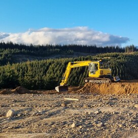 Two Komatsu excavators shaping a hillside section at golden hour – precision earthworks by North Canterbury civil contractors.