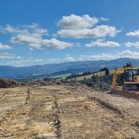 Two Komatsu diggers working on a hillside under blue skies – professional earthmoving and excavation services in North Canterbury.