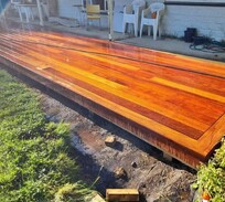 Gloss-finished hardwood deck with a contrasting border pattern – expertly built by North Canterbury deck builders for stylish outdoor living.