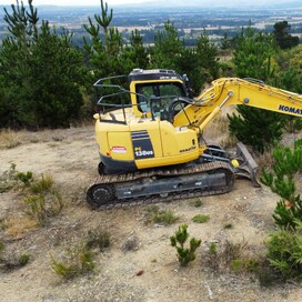 Komatsu excavator clearing rugged hillside terrain in Canterbury – reliable earthworks and excavation services North Canterbury.