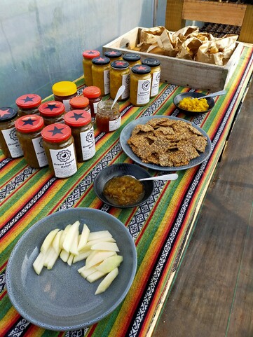 table with jars of chutney, bowls filled ad crackers on plate ready to serve