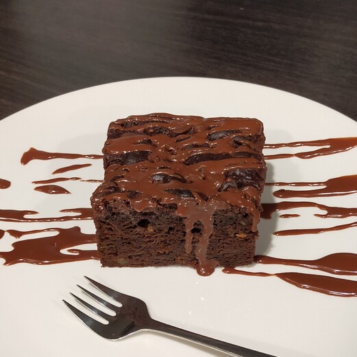 chocolate cake with chocolate drizzle on white plate