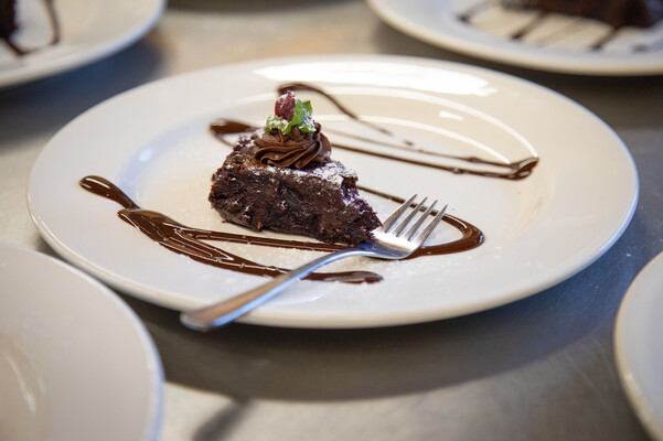 brownie with ganache on plate with chocolate drizzle
