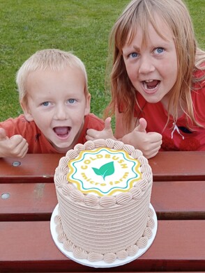 2 children giving thumbs up with Goldbushcake