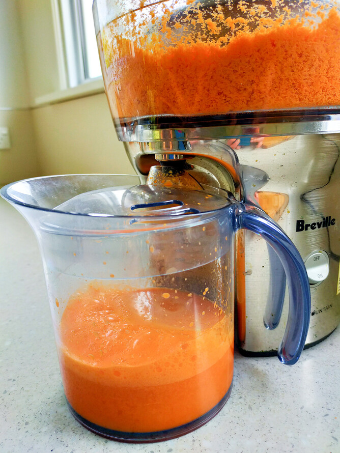 carrot juice coming out of juicer