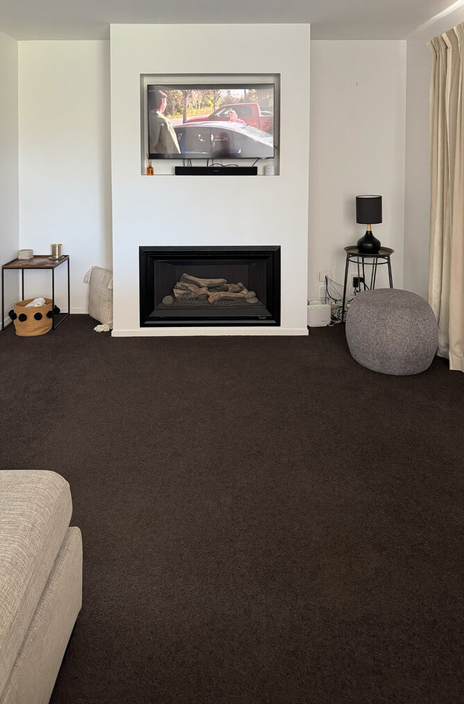 BEFORE: The living room was uninviting, with dark carpet and patterned curtains.