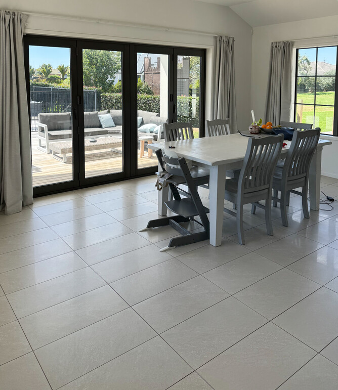 BEFORE: Dining room with grey tiles and grey curtains. Tile floors are often too cold underfoot in cooler months.