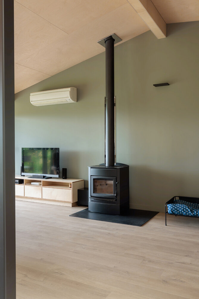 After image showing new flooring with green feature wall and ply ceiling