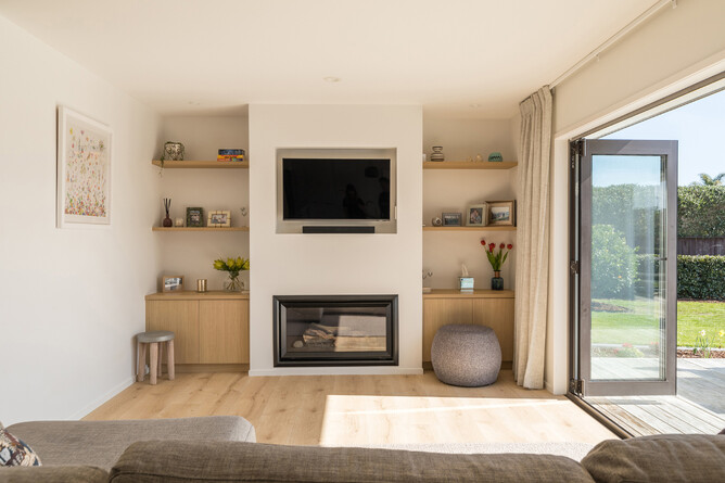 AFTER: The living room has become a light and airy space to enjoy. The space flows to the outdoor entertaining area and pool. Our high-quality laminate flooring is ideal for durability in sunlit and wet areas.