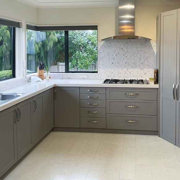A modern dark grey kitchen with a white cork floor.