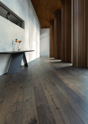 A dark wood floor in a white kitchen.