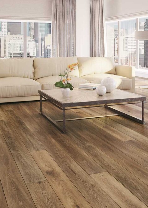 Medium wood look vinyl hybrid floor in a lounge with a low coffee table and white sofa.