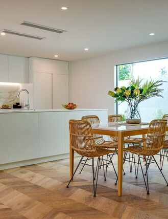 Chevron oak flooring in an open plan kitchen and dining room.