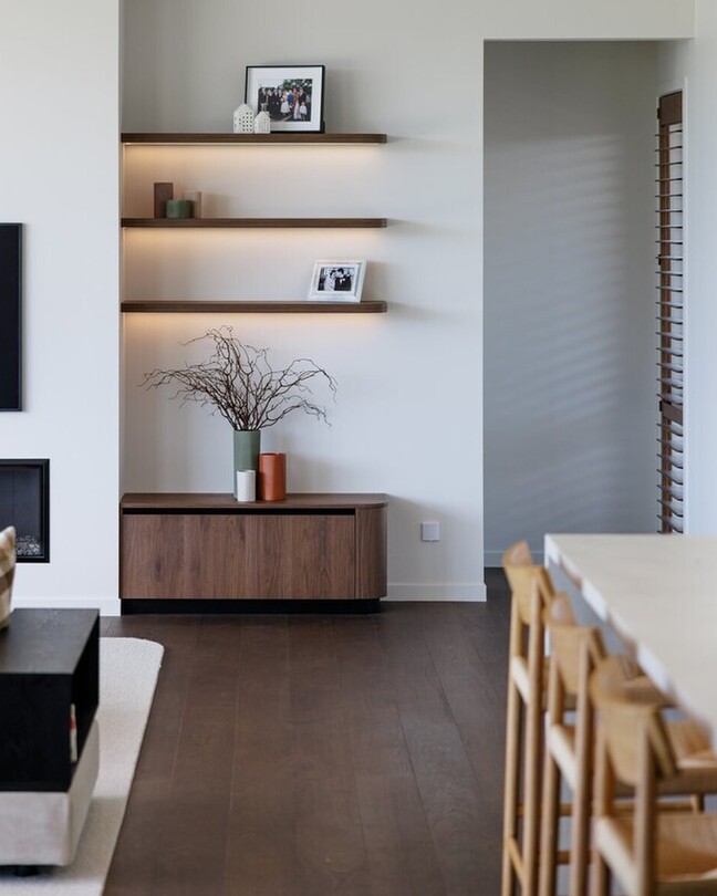 Natural wood floor and black fireplace in a lounge setting.
