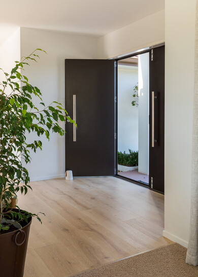 A white kitchen with natural varnished oak laminate flooring.