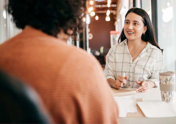 A lady interview a client for a position at a restaurant